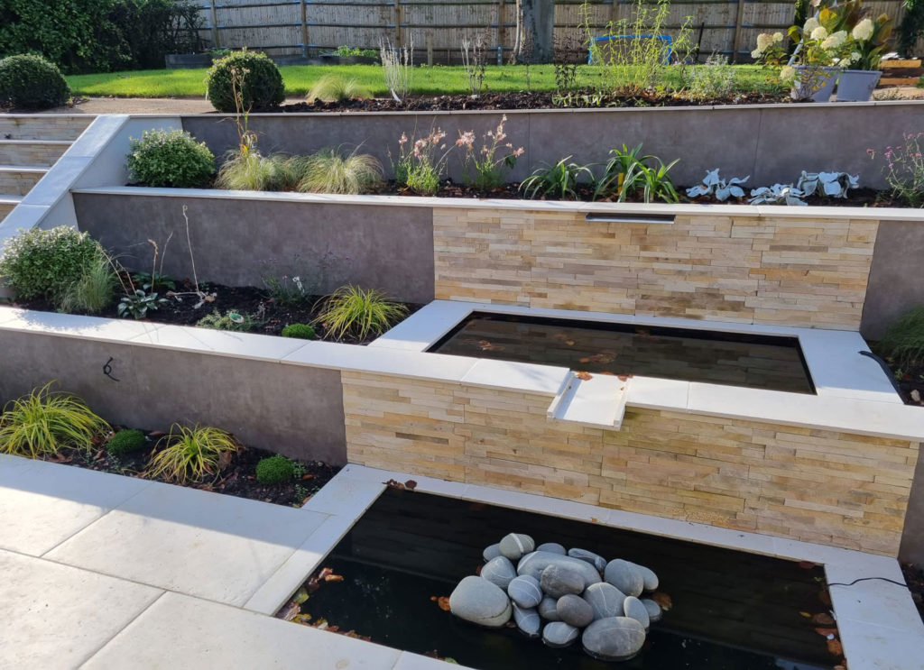 modern water feature incorporated into a series of three retaining walls
