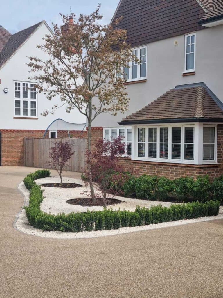 elegant front garden with resin bound driveway and colourful trees